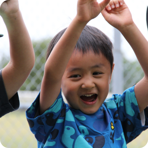 adrian as a child, with hands raised