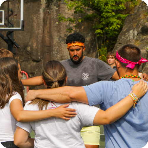 volunteers together in a circle with arms over shoulders