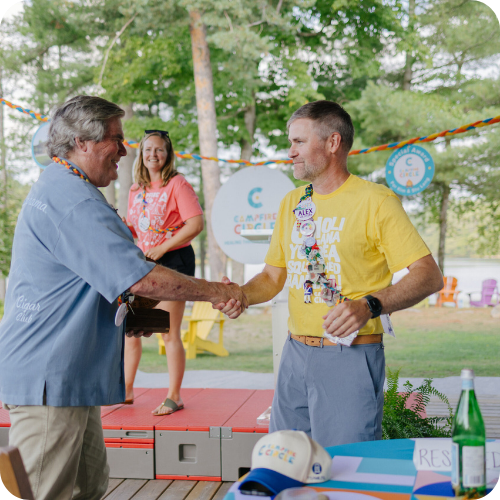 stu lang and alex shaking hands, with ashley in background