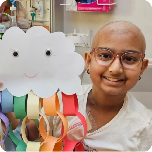 sophie in hospital bed holding her artwork
