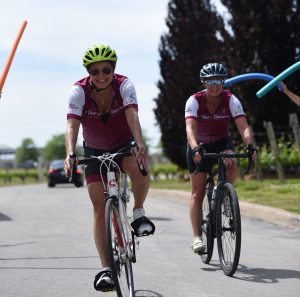 bikers with pool noodles surrounding them